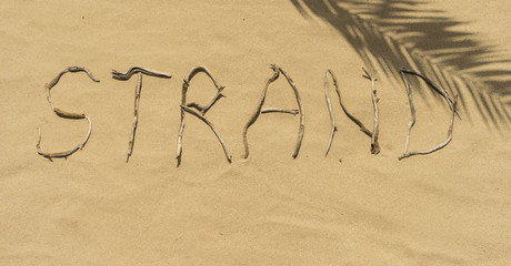 Wort STRAND aus Treibholz im Sand