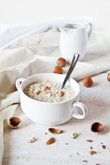 Oatmeal porridge in a bowl with hazelnuts