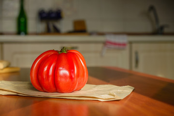 Beef Heart tomato, Olena Ukraina, on the kitchen table illuminated by the morning sunlight