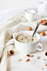 Oatmeal porridge in a bowl with hazelnuts