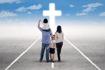 Young family follow a cross on the road