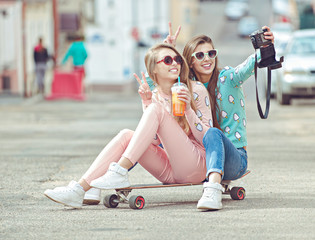 Hipster girlfriends taking a selfie in urban city context -