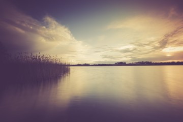 Vintage photo of beautiful sunset over calm lake