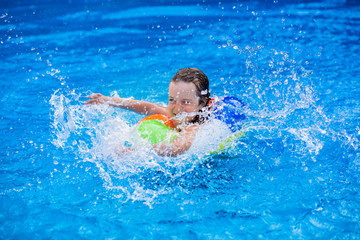 Fototapeta na wymiar Child playing in swimming pool