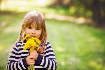Beautiful little blonde girl, playing outdoor, springtime