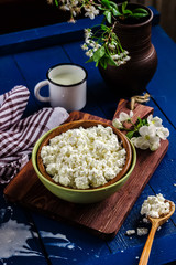 Cottage cheese in a bowl on blue wooden table