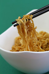 Chinese noodles on chopsticks, closeup
