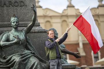 Young man with the Polish flag near Mickiewicz monument .