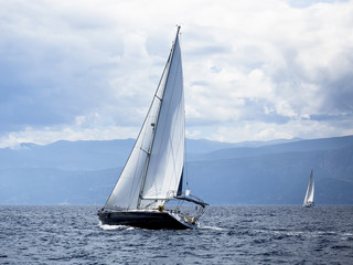 Fototapeta na wymiar Sailing in the wind through the waves at the Aegean Sea.