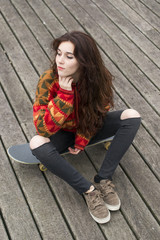 Obraz na płótnie Canvas Beautiful hipster young woman sitting on skateboard.