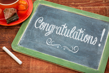 congratulations on blackboard with a cup of tea