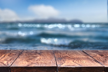 Empty wooden table with sea on background