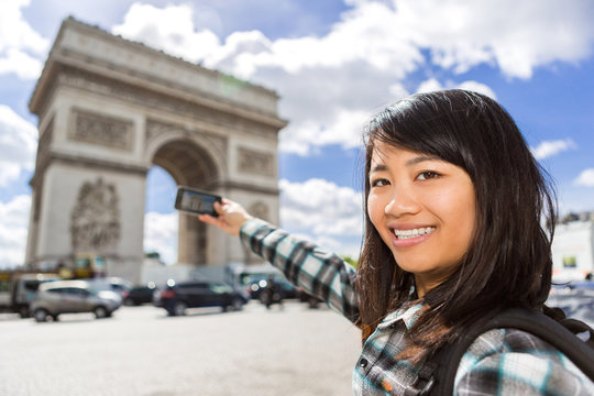 Young attractive asian tourist taking pictures in Paris
