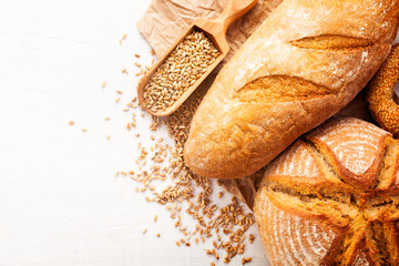 Assortment of baked bread on white wooden table background