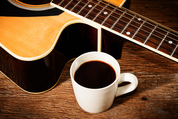 coffee cup and guitar on wooden table