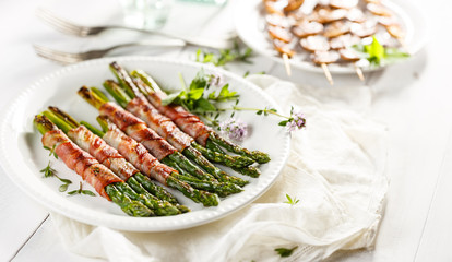 Grilled green asparagus wrapped in bacon