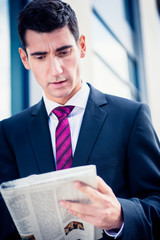 Man in suit reading newspaper