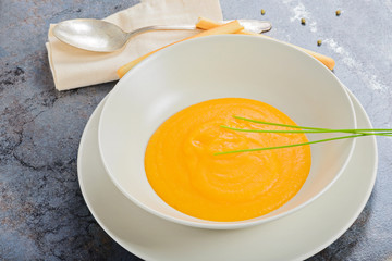 Pumpkin creamy soup with spoon and napkin