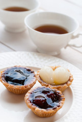 Fruit tart with tea on wooden board