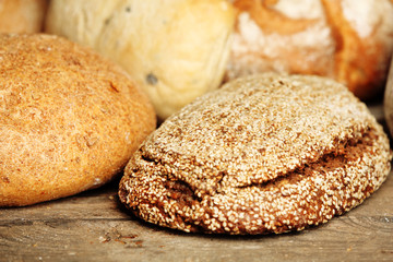 Different fresh bread on old wooden table