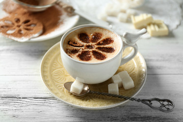 Cup of latte coffee art on wooden table, on light background
