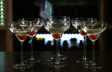 Glasses of cocktails on bar background