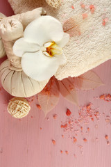 Still life with beautiful blooming orchid flower, spa treatment and pebbles, on color wooden background