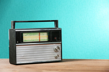 Old retro radio on table on green wall background