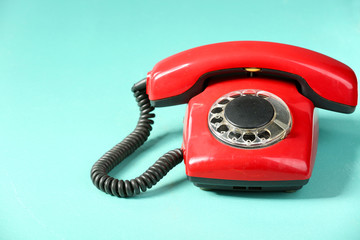 Retro red telephone on table on green background