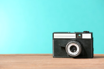 Retro camera on table on green background