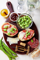 Fototapeta na wymiar Italian snacks. salami sandwich with parmesan cheese & broad bea
