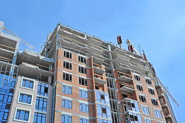 Fototapeta premium Crane and building construction site against blue sky