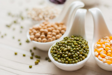 Different kinds of bean seeds, lentil, peas in dish on wooden
