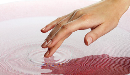 Finger touches water close up