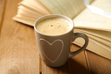 Still life with cup of coffee and book, on wooden table