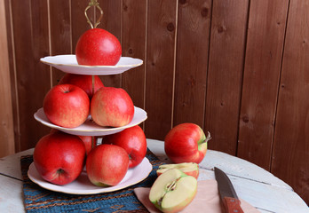 Tasty ripe apples on serving tray on wooden background