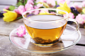 Cup of herbal tea with flowers on wooden background