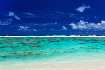 Obraz premium Tropical beach with coral reef and surf waves on Cook Islands