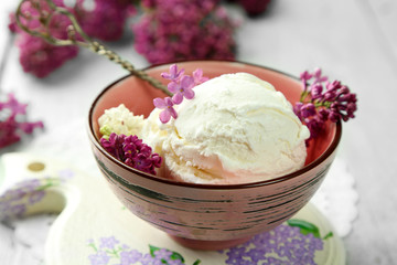 Beautiful composition with tasty ice cream and lilac flowers