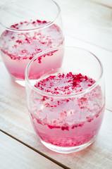 Pink Cocktail with fresh rose petals on wooden table