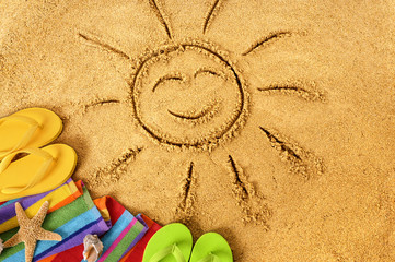 Summer beach smiling sun happy smiley face drawing drawn in sand with accessories holiday vacation...