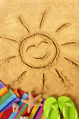 Summer beach smiling sun happy smiley face drawing drawn in sand with accessories holiday vacation...