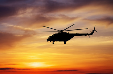 Naklejka na ściany i meble Picture of helicopter at sunset. Silhouette of helicopter on sun