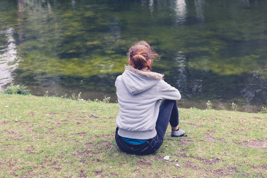 Woman sitting by water in the park
