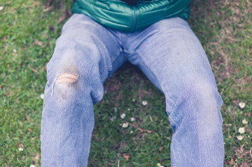 Man with torn jeans on grass