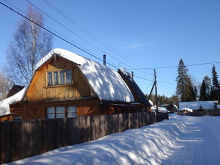 Fototapeta na wymiar Деревенская улица с деревянными домами зимой