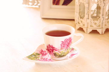 Black tea in elegant vintage porcelan cup on vintage table
