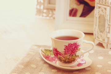 Black tea in elegant vintage porcelan cup on vintage table