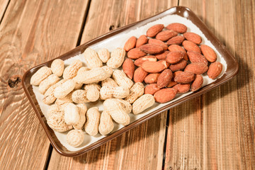 peanuts and almond on wood background