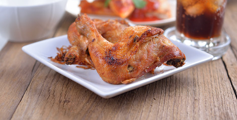  fried chicken on a white plate set on a wood table